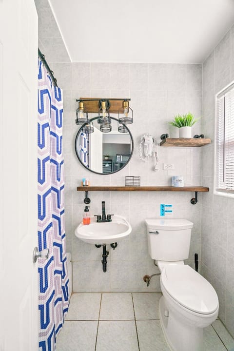 Boutique Beach Retreat tiled full bathroom Shower and tub Hair dryer, sink, toilet, Great natural lighting and storage.