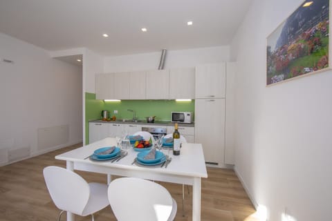 The living room with dinner table and view of the kitchen