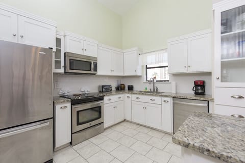 The spacious kitchen features sleek stainless steel appliances and a large center island, perfect for cooking and gathering.
