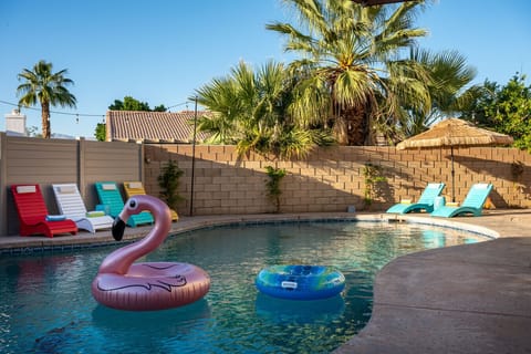 Pool side: large pool and spa, sun loungers with cantilever umbrellas, and outdoor fire pit