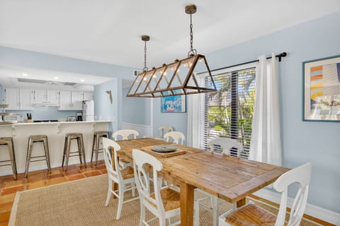 Dining area featuring a rustic farmhouse table and an abundance of natural light, opening to the kitchen for easy entertaining.