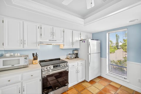 Bright and open kitchen with ample counter space, white cabinetry, and modern appliances—ideal for preparing meals and gathering together.