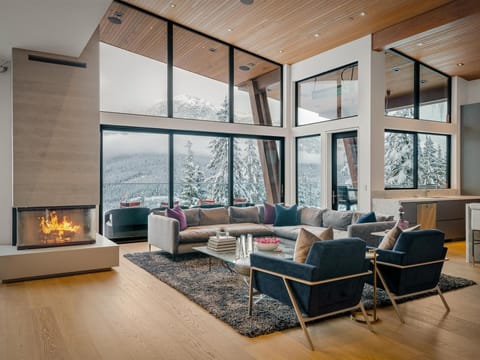Impressive panoramic views from all rooms, including the grand great room with floor-to-ceiling windows, cosy wood-burning fireplace, large heated terrace