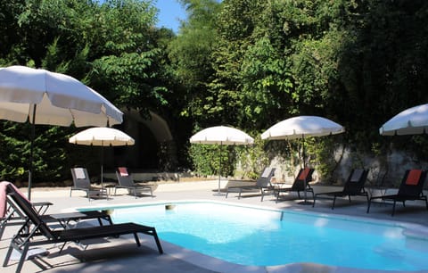 Pool with shower, lounge chairs and umbrellas