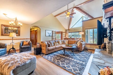 Spacious living area featuring large wood burning fireplace, ample seating and sweeping mountain views.