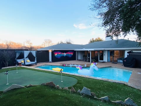 Patio with daybed, glow in dark mural, mini golf, heated pool and grill