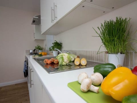 Close-up of white kitchen countertop with herbs, vegetables, pepper, and mushrooms for self-catering guests – Castle 6 - Southampton