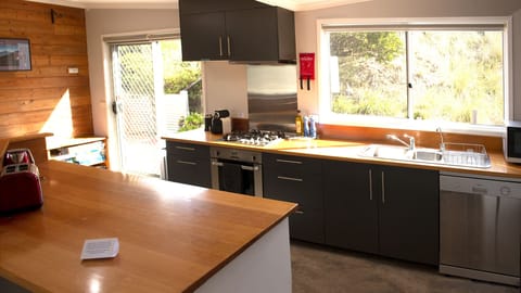 Bright and open fully-equipped kitchen with direct access to the BBQ sundeck.