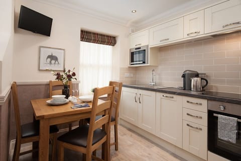 Eildon View - dining area with seating for four and small wall-mounted TV