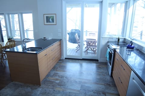 Kitchen with sliding glass door to outdoor eating area/porch.