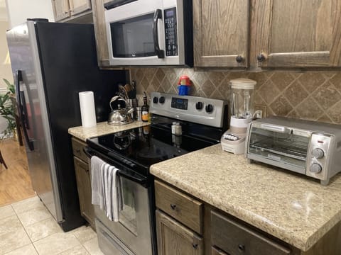 Galley kitchen tea pot, toaster oven, air fryer, microwave, & blender.