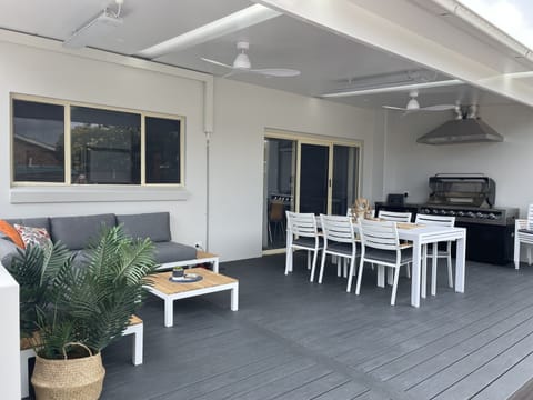 Large rear deck with BBQ and outdoor furniture and ceiling fans.