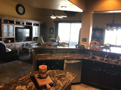 Wide view of living room, dining room, patio doors, partial kitchen. 