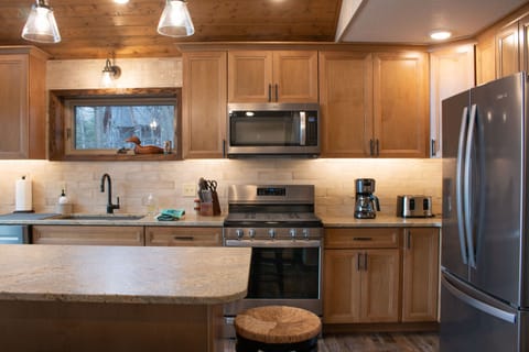 Kitchen with gas stove, toaster, coffee pot, fridge with filtered water