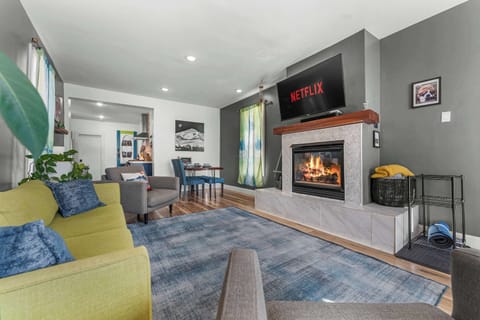 A modern living room with a fireplace and TV above it.