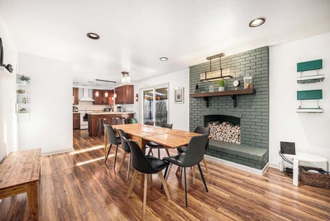 - Bright and welcoming dining area with warm wood tones and a playful modern hearth
- Gather for meals or game nights just steps from the fully equipped kitchen
- Easy patio access and bar seating make this the heart of your stay