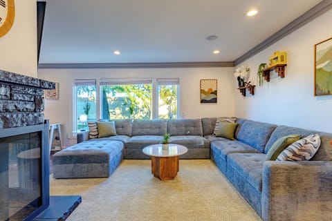 Living room with large sectional, wood fireplace and 55in smart TV.