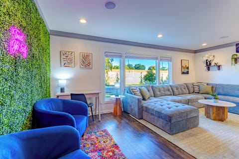 Desk workspace with lamp and additional living room seating with comfy chairs and plant wall for the perfect photo ops.