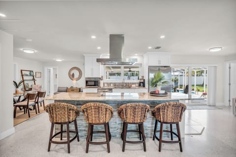 Modern kitchen with island seating and poolside view, perfect for entertaining.