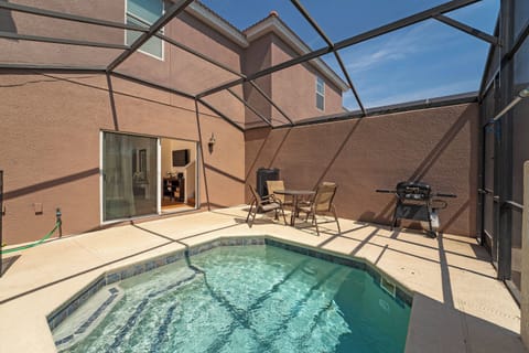 Step outside to your private oasis, where a sparkling pool awaits beneath a protective screen. The sun-drenched patio features comfortable seating and a grill, perfect for relaxing afternoons and evening barbecues.