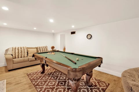 Bright game room featuring billiards and lounge area, inviting guests to relax and play together