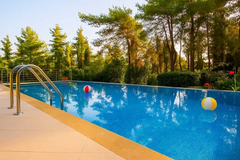 Daytime View of the Pool Area
Sparkling blue waters and lush greenery for a refreshing swim experience.