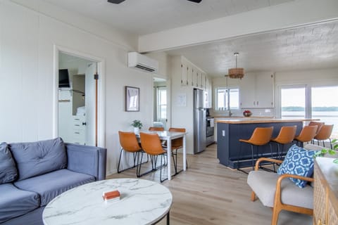 Full living area with sectional, chair, smart TV, and Blu-ray/DVD player. Open concept with kitchen and dining area. Walk out to the covered back porch where there's outdoor seating as well.