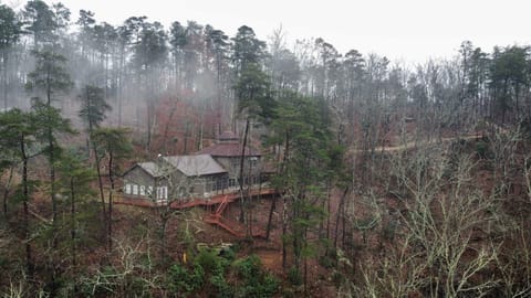 View of the cabin, deck, and driveway from over the canyon