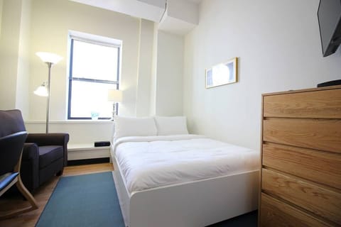 This unit features carpet throughout, there is  queen size bed, a separate wardrobe, and dresser for hanging and storing clothes, plus comfortable seating. This place is seconds to Orange Line and Silverline