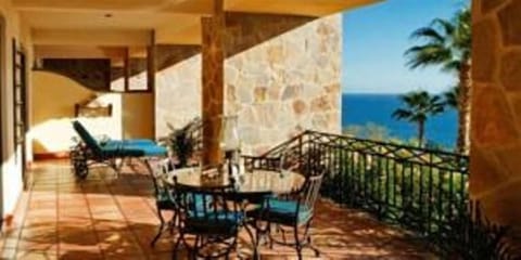 The spacious porch overlooking the  beach and ocean invites lounging and dining.