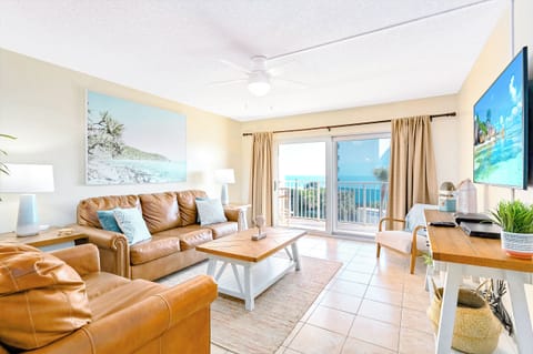 A cozy living room with warm tones and a view of the balcony