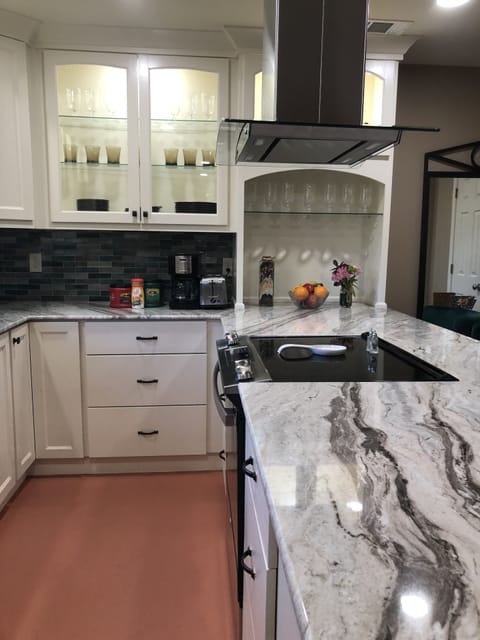 Electric stove on a peninsula, granite counter tops.