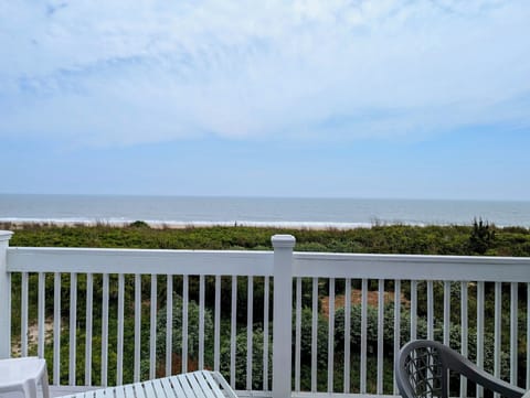 289B Bunting Ave, Fenwick Island - Ocean Front Deck - An expansive, wide-angle view from the top balcony showcasing the sandy beach, coastal dunes, and the Atlantic Ocean under a clear sky.