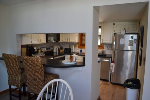 Kitchen with bar stools. Opens to dining room and living room. Open floor plan.