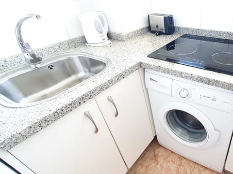 Ceramic hob and washing machine in the kitchen/ Placa vitrocerámica y lavadora en la cocina