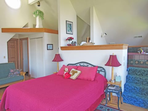 Elevated, jetted tub behind the queen-sized bed.