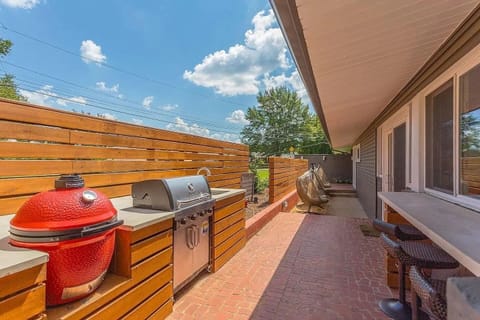 Outdoor Kitchen - Partially covered kitchen sited on the front of the home extends the living spaces outdoors, and features all new appliances—including both a gas grill and Kamado Joe egg grill. Bar-stool seating.