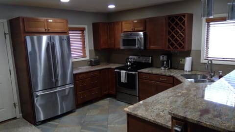 Remodeled kitchen with stainless appliances, new granite, and maple cabinetry.