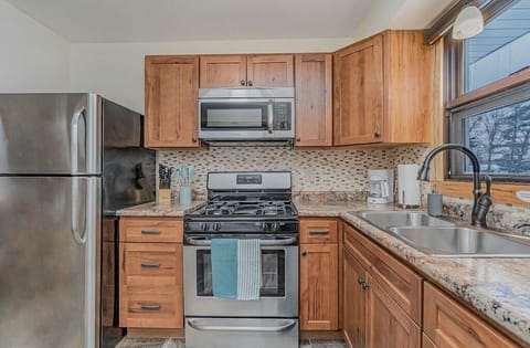 Fully stocked kitchen with stainless steel fridge, microwave, and oven/stove.