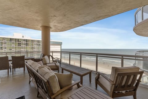 Spacious oceanfront balcony with cozy seating and stunning views