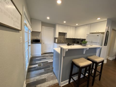 Kitchen with coffee maker, microwave, blender and toaster.