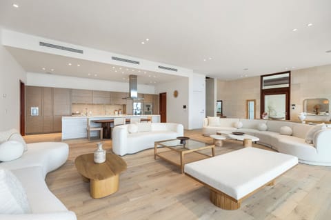 Open-concept layout seamlessly connects the dining table, living room, and kitchen, ideal for group entertainment.