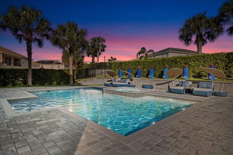 - Sparkling private pool with relaxing spa and loungers  
- Palm trees and evening sunsets create a tropical retreat  
- Orlando vacation home with outdoor entertainment space