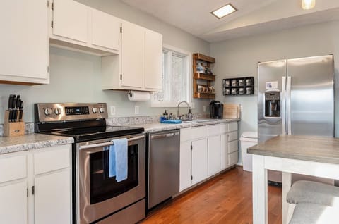 Ceramic top stove, blender, toaster, baking pans, and pots in kitchen