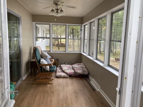 Three seasons sunroom with a ceiling fan and light great views of the lake