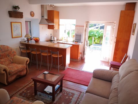 Kitchen door opens onto sunny breakfast terrace 