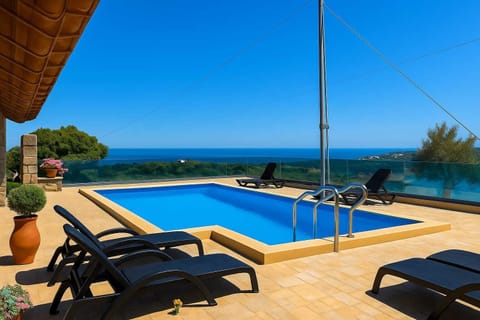 Expansive Shared Pool Area with Sun Loungers – Large shared pool between two properties, complemented by sunbeds and uninterrupted sea views.
