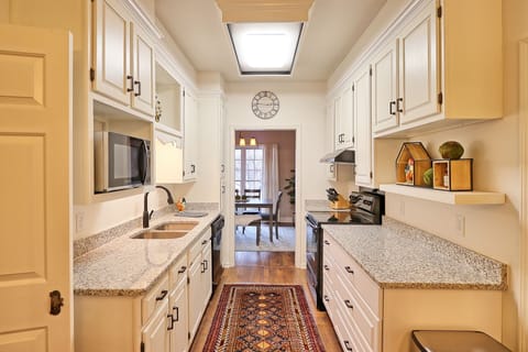 Black & white galley kitchen is fully stocked for eating in.