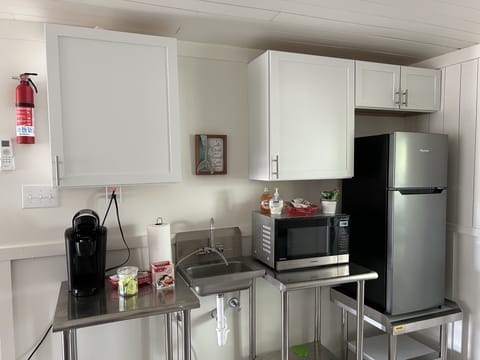 Mini-kitchen downstairs equipped with Keurig coffee maker and refrigerator 
