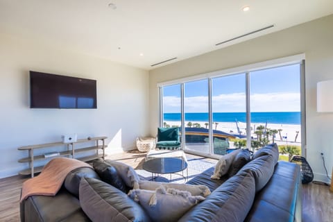 Living room with a luxurious leather couch, TV and views from every angle of the room.